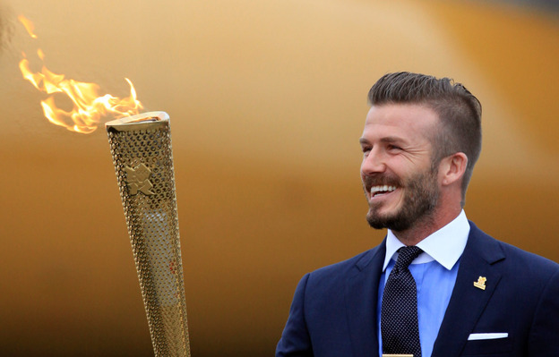 David Beckham holds the Olympic Flame as it arrives at RNAS Culdrose near Helston in Cornwall, England.