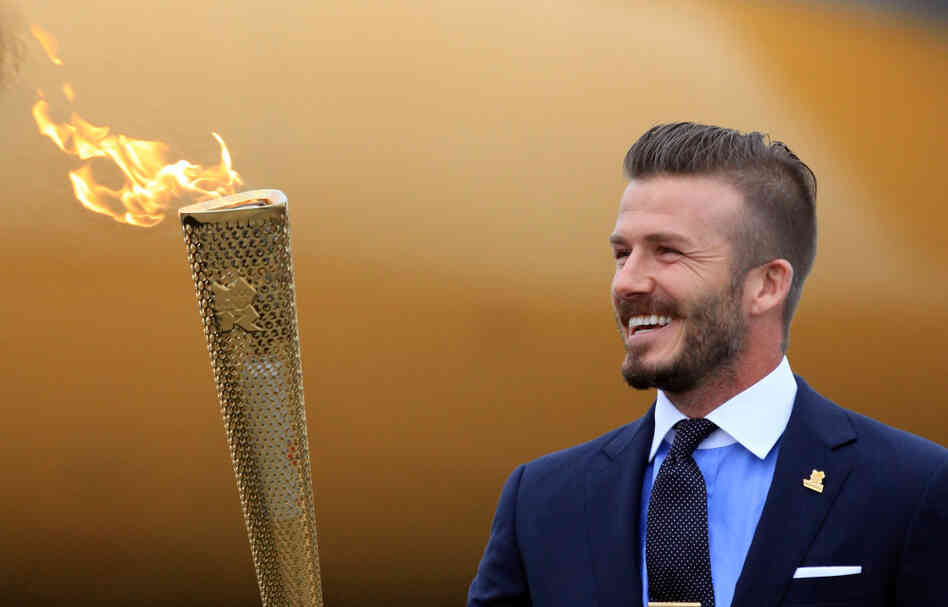 David Beckham holds the Olympic Flame as it arrives at RNAS Culdrose near Helston in Cornwall, England.