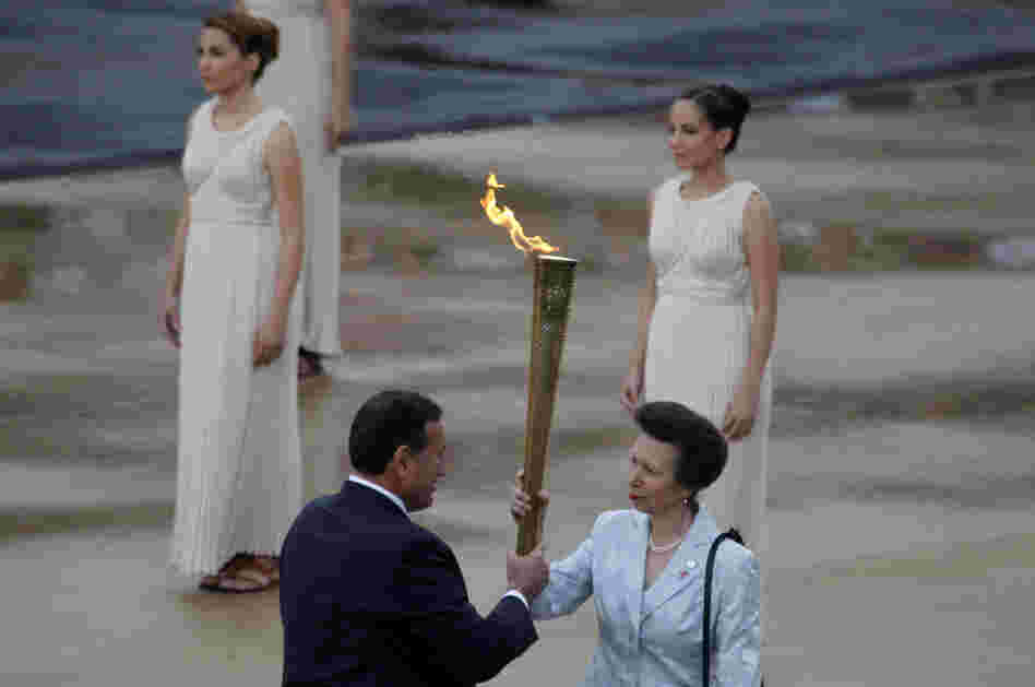 President of the Greek Olympic Committee Spyros Kapralos passes the torch to Britain's Princess Anne, right. President of the Greek Olympic Committee Spyros Kapralos passes the torch to Britain's Princess Anne, right.