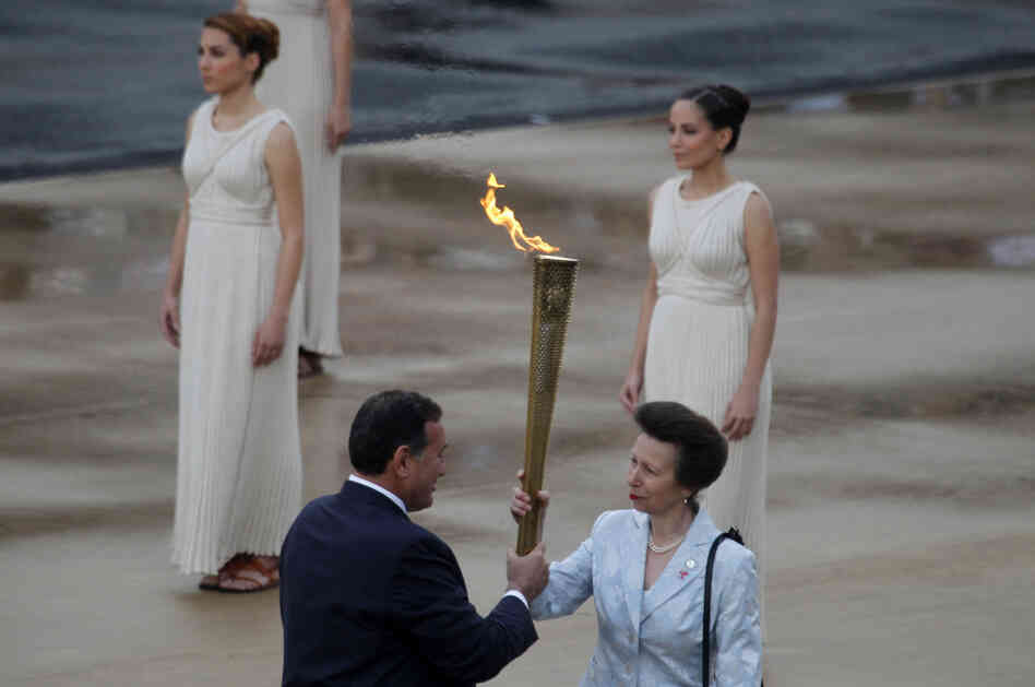 President of the Greek Olympic Committee Spyros Kapralos passes the torch to Britain's Princess Anne, right. President of the Greek Olympic Committee Spyros Kapralos passes the torch to Britain's Princess Anne, right.