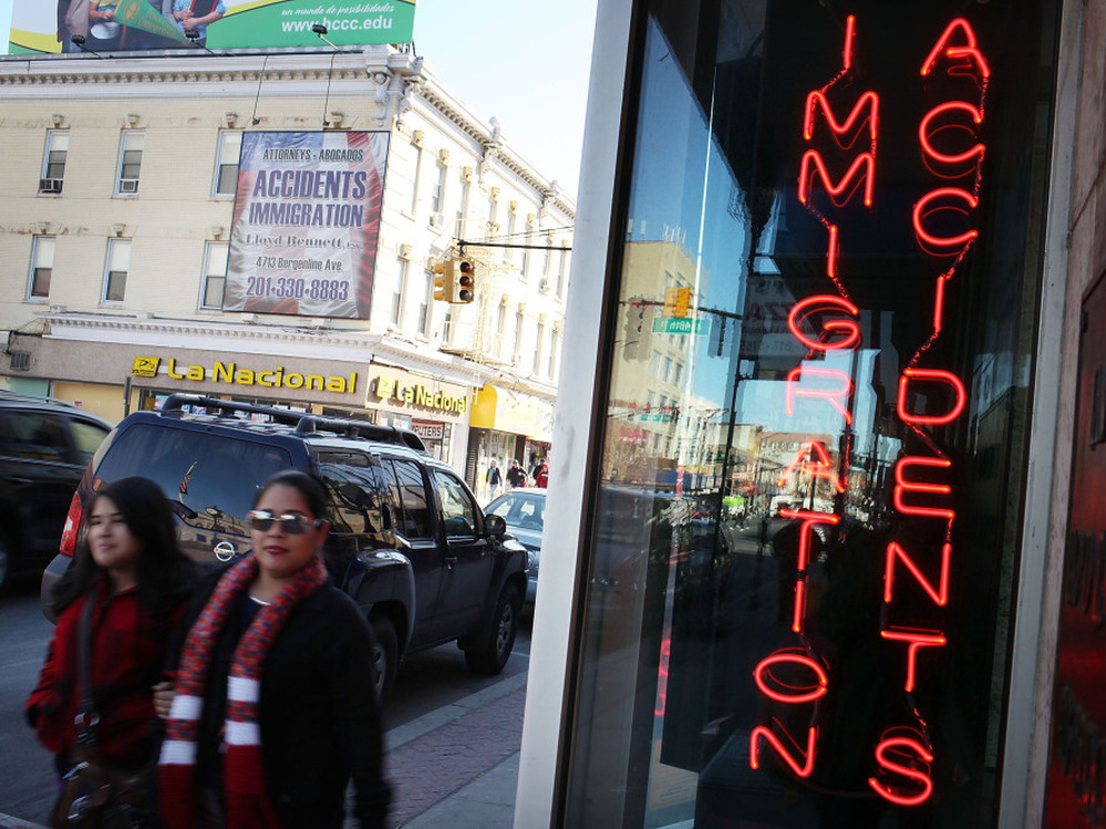 Hispanic residents walk by a law office in Union City, N.J., specializing in immigration in March. Union City is one of the state's largest cities, and has a Hispanic population of more than 80 percent.