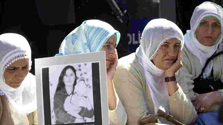 A woman holds a photo of Guldunya Toren, an unmarried mother allegedly killed by her brothers for having a child out of wedlock, outside parliament in Ankara, Turkey, in 2004. Her case prompted huge protests and forced Turks to realize that the justice system often fails to protect at-risk women.