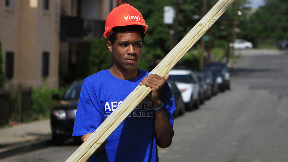 Domingo Williams, a participant in the Sasha Bruce Youthwork program, gathers wood to help rebuild a gutted house in the Southeast neighborhood of Washington, D.C.