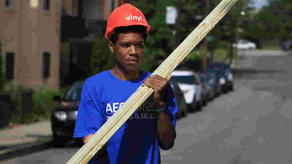 Domingo Williams, a participant in the Sasha Bruce Youthwork program, gathers wood to help rebuild a gutted house in the Southeast neighborhood of Washington, D.C.
