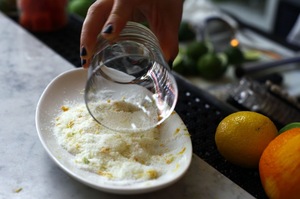 Rub half a lime around the rim of the glass. Dip the rim into the salt. For less salt: Make a lipstick-sized mark on the rim instead of coating the whole thing. Then, tap the outside of the glass in the salt.