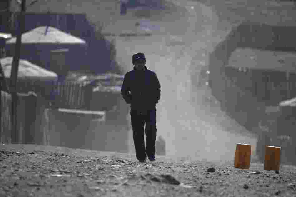 A ger district resident walks the dusty streets on the outskirts of Ulan Bator. As Mongolia's mining industry continues to grow, the future of the country's traditional ways is unclear.