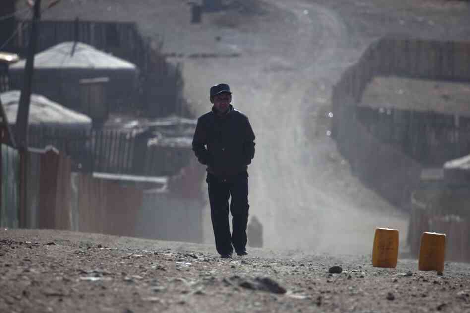 A ger district resident walks the dusty streets on the outskirts of Ulan Bator. As Mongolia's mining industry continues to grow, the future of the country's traditional ways is unclear.