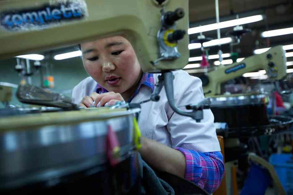 A seamstress performs delicate work on a piece of cashmere cloth at the Gobi factory. The cashmere industry is also feeling the effects of mining — as inflation has driven up the cost of raw materials, and water shortages and shrinking pastureland threaten herds.