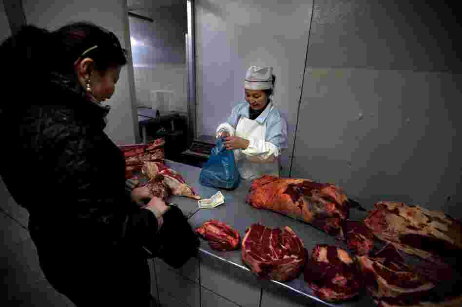 Mutton is a staple of the Mongolian diet. A woman buys meat from a butcher in Ulan Bator's central market.