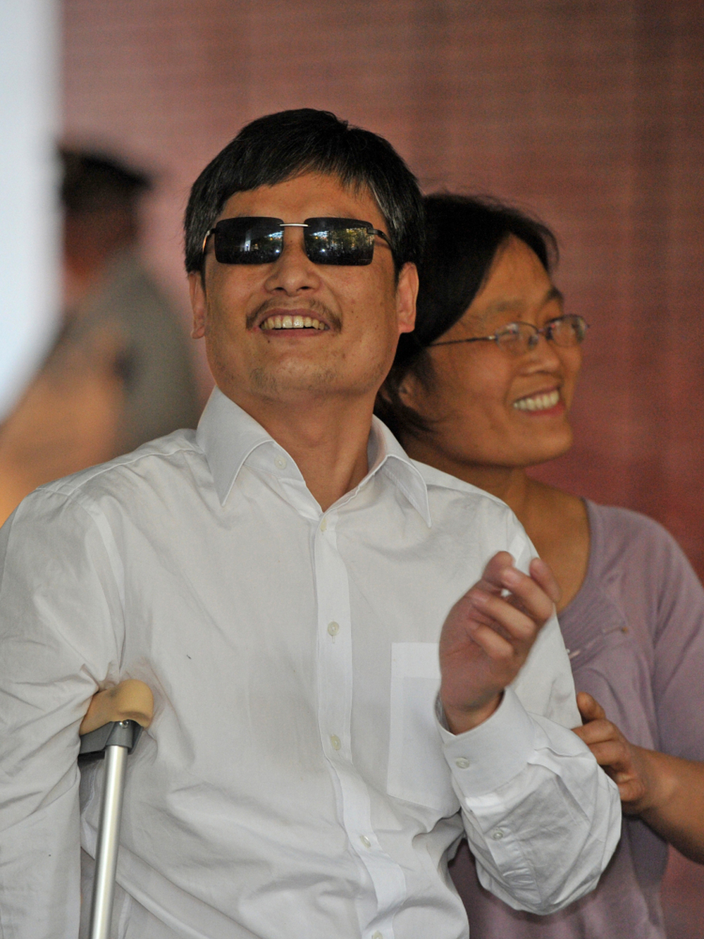 Chinese activist Chen Guangcheng and his wife, Yuan Weijing, arrive at an apartment complex in New York on Saturday. A number of Chinese activists have become far less prominent after leaving their homeland, but Chen hopes to continue his work and remain relevant in China.
