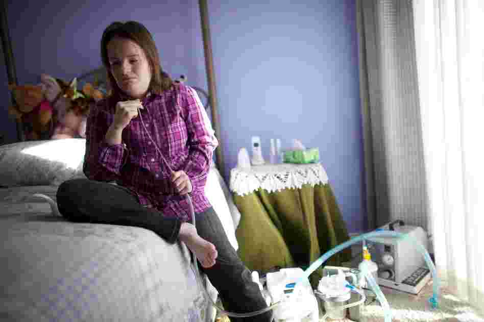 Katie Beckett, 32, inserts a small suction device into her tracheotomy tube to help clear her lungs and throat. Twenty-nine years ago, President Ronald Reagan heard about a little girl who had spent most of her life in a hospital. That little girl was Katie, then just three years old.