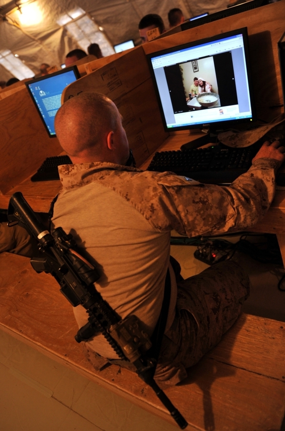 At Forward Operating Base Payne in Afghanistan's Helmand province, Marine Cpl. Jonathan Odriscoll looks at pictures of his sister on Facebook. Troop access to social media has been both a blessing and curse for the military.