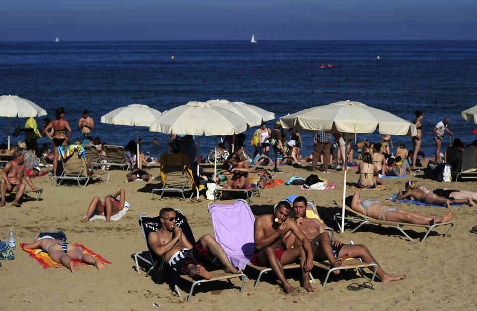 People relax at a beach in Barcelona, Spain, on a Monday last summer. Many Spanish workers are upset that some traditional four-day holiday weekends might be scaled back to just three days. People relax at a beach in Barcelona, Spain, on a Monday last summer. Many Spanish workers are upset that some traditional four-day holiday weekends might be scaled back to just three days.