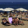 People relax at a beach in Barcelona, Spain, on a Monday last summer. Many Spanish workers are upset that some traditional four-day holiday weekends might be scaled back to just three days.