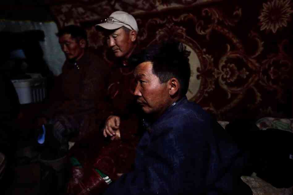 Ex-herders work at a makeshift truck stop for mining trucks. Most say their water supply dried up, leaving them no choice but to sell their animals.