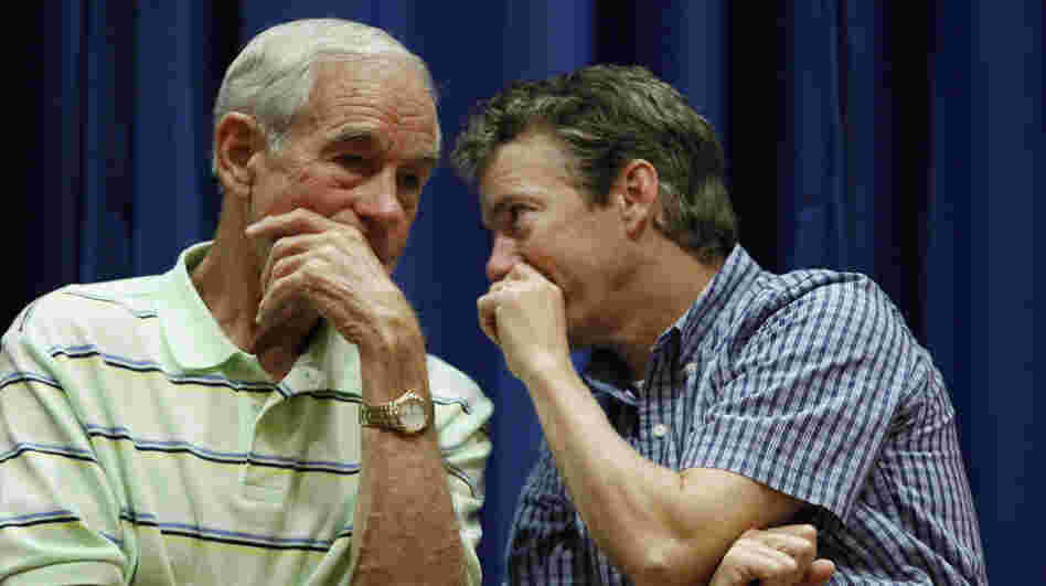 Rep. Ron Paul, R-Texas, and his son, Sen. Rand Paul, R-Ky., talk at a campaign event for the elder Paul in Des Moines, Iowa, last August.