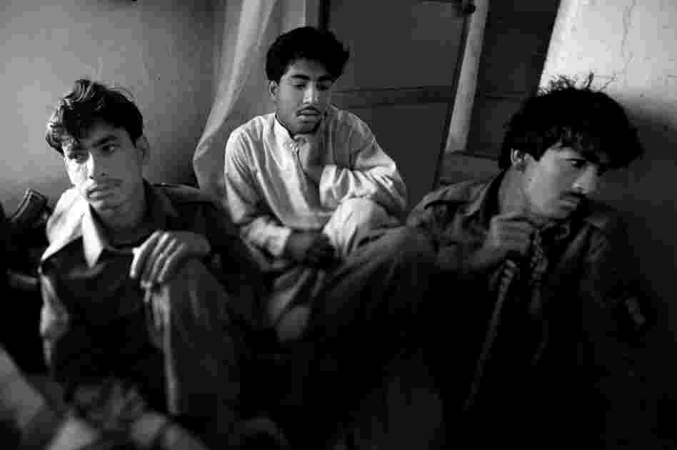 Afghan police officers listen to instructions from their commanders at their makeshift headquarters before going out on patrol.
