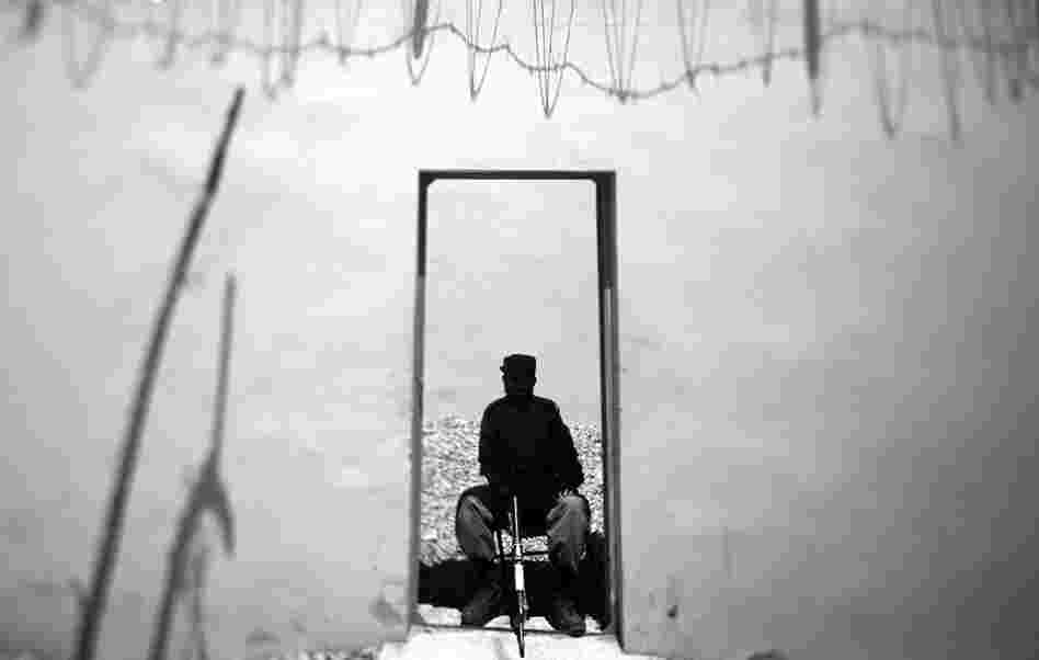 An Afghan policeman guards the entry point to a brand new police station near a busy market.