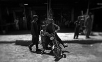 A man rides a motorcycle at a bustling Marjah bazaar. The market was the scene of bitter fighting between U.S. Marines and Afghan insurgents in February 2010.