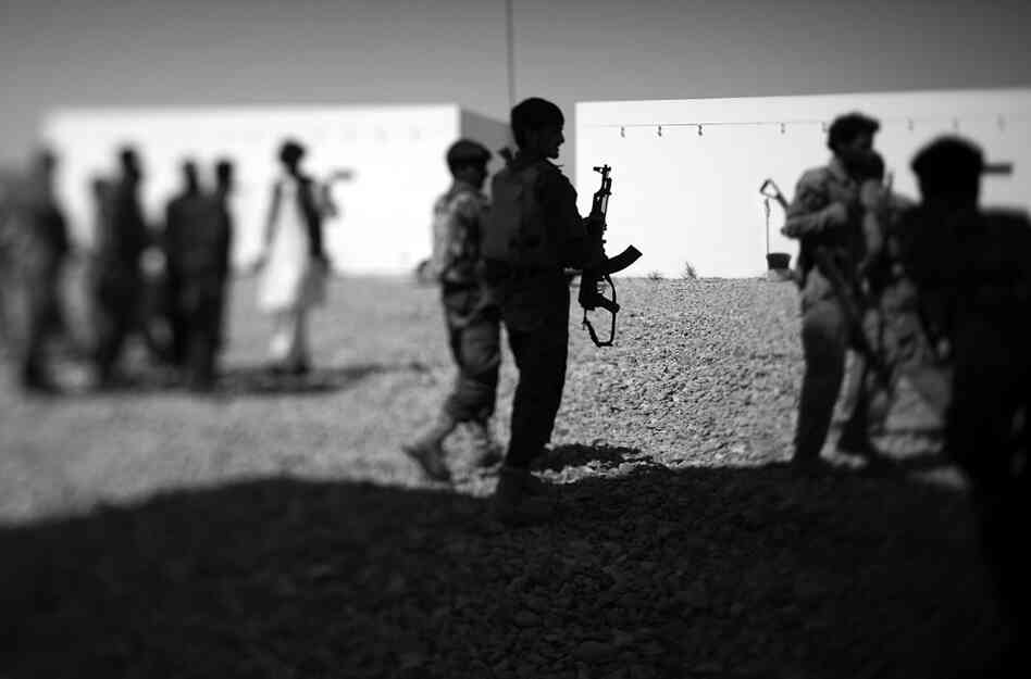 Afghan police officers wait outside a classroom at their recently built training facility.