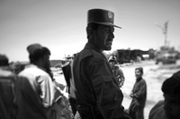 Abdullah Jan, an Afghan police officer, walks through a crowded market in Marjah. He tells US Marines he is confident that the Afghan police can maintain calm in this former Taliban stronghold.