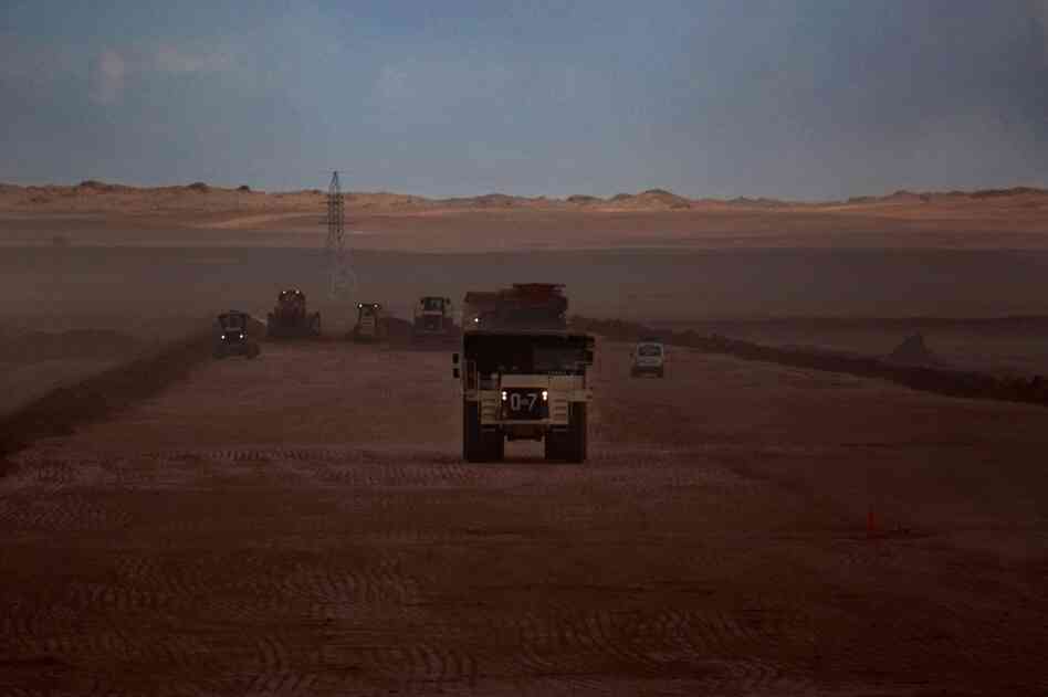 Trucks haul massive loads of dirt along an Oyu Tolgoi road.