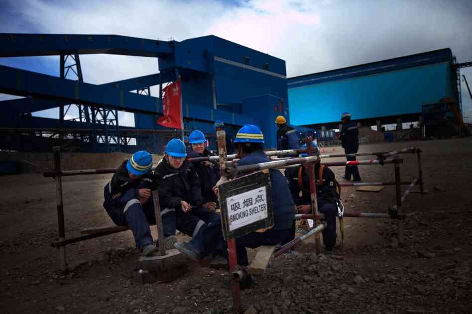 A group of Chinese workers takes a smoke break at Oyu Tolgoi. The company has imported thousands of skilled Chinese workers to help finish the mine infrastructure.