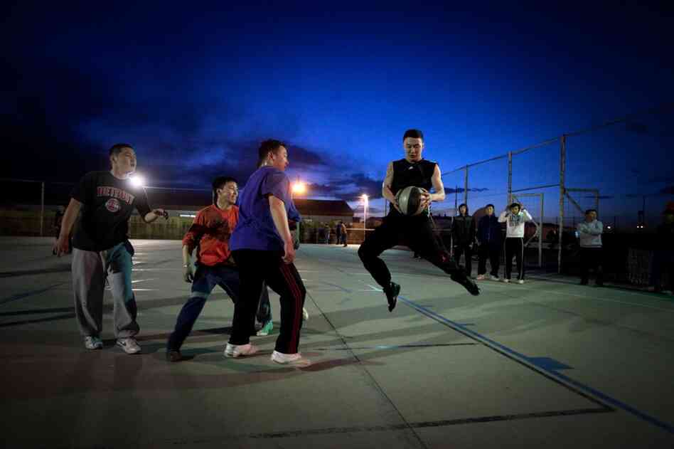 At the mine camp, workers relax by playing basketball.