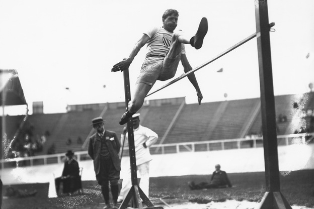 Ray Ewry wins the standing high jump at the 1908 Summer Olympics in London. Ewry won 10 gold medals, all after having overcome polio as a child.