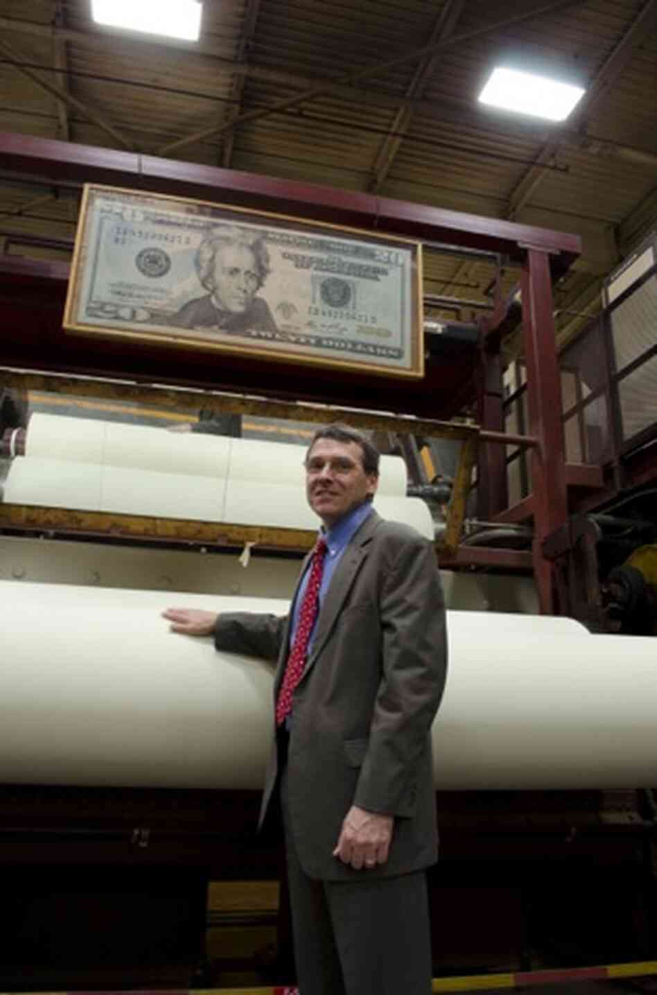 Crane & Co. Vice President Doug Crane stands near a spool of paper used for $20 bills, as it spins at the company's Wahconah Mill.