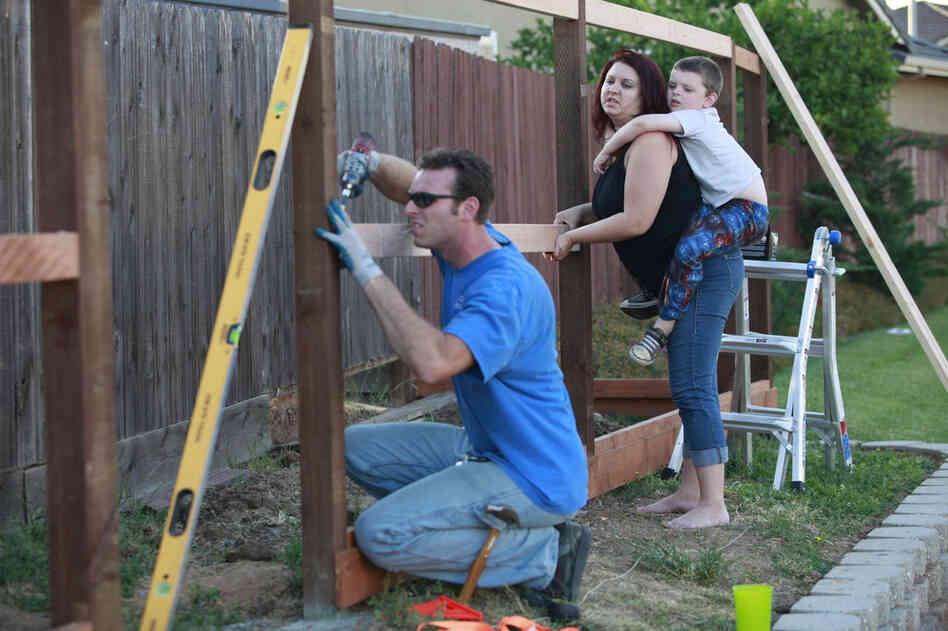 After coming home from his job, Kevin works on a fence he is building around their home. The Coopers have stopped taking trips, eating out and spending money on anything else they don't need.