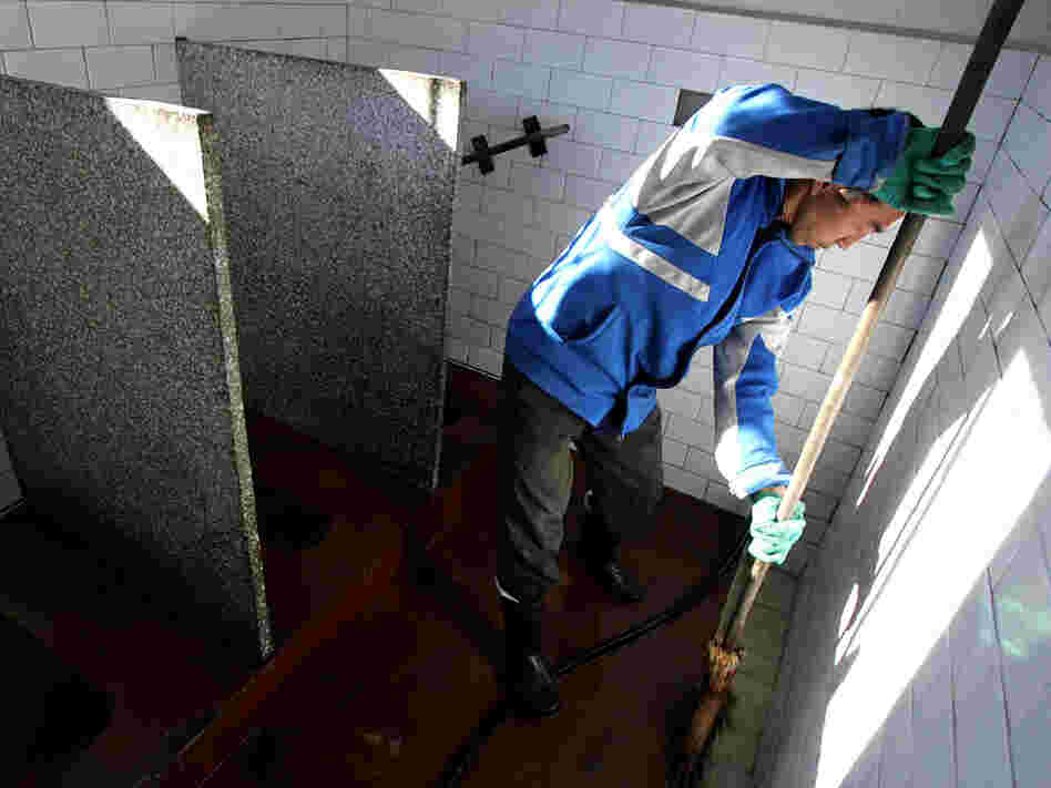 A worker cleans a public bathroom in Beijing. New rules require that public restrooms in the Chinese capital have no more than two flies in them.