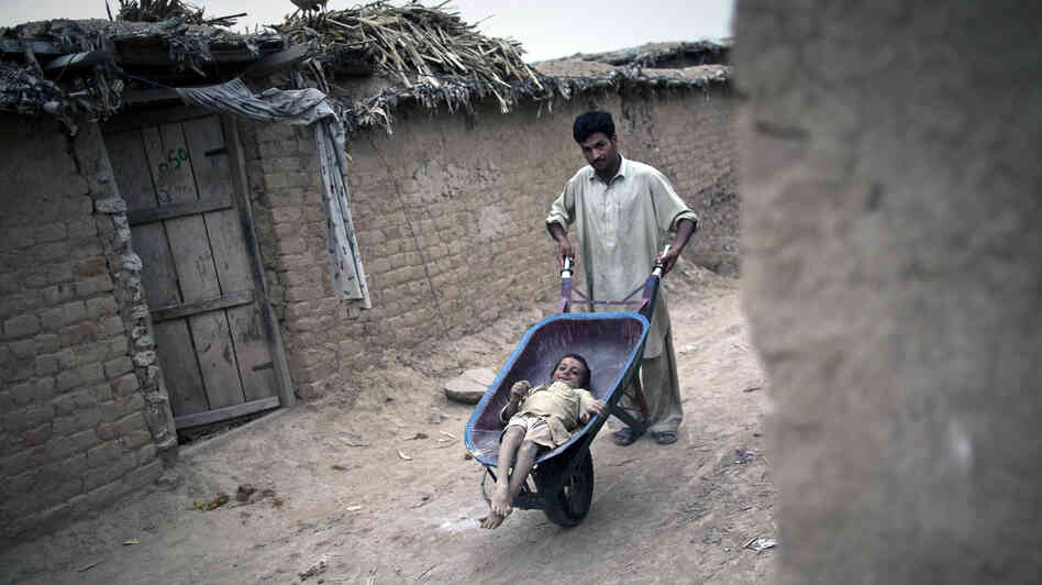 A Pakistani man wheels Jamshid, an 8-year-old girl with polio, around the outskirts of the capital Islamabad last July. A Pakistani man wheels Jamshid, an 8-year-old girl with polio, around the outskirts of the capital Islamabad last July.