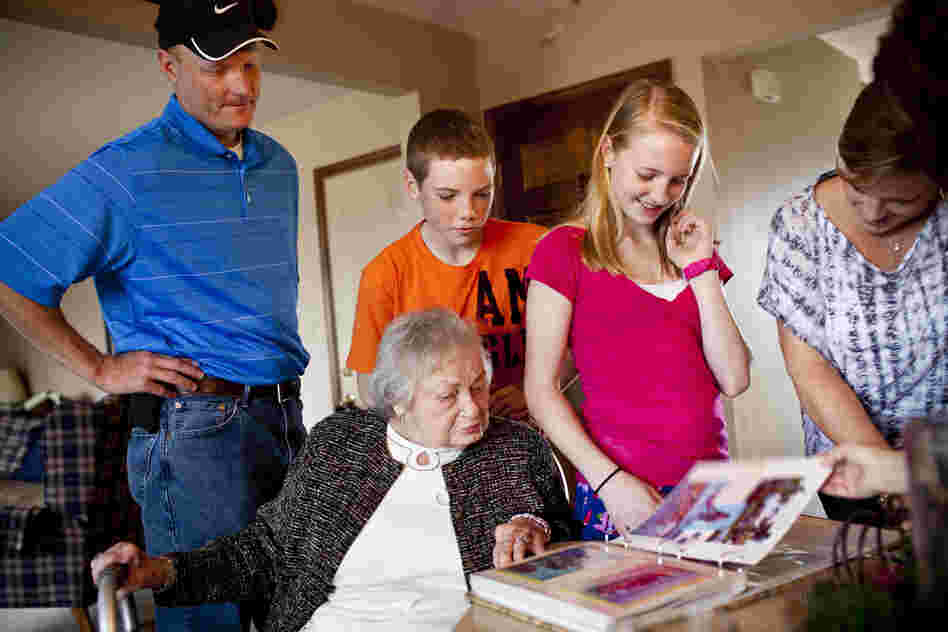 The Martin family (from left) — David; Chris, 14; Lauren, 12; and LaDonna — gather around AnnaBelle as they look through a photo album of a family vacation.