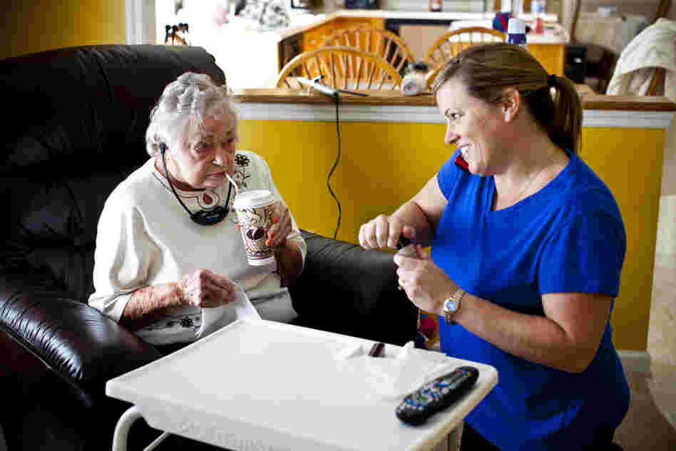 LaDonna talks on the phone with AnnaBelle's granddaughter and LaDonna's sister-in-law, Kelley Hawkins, while helping AnnaBelle with her makeup in her family's living room.