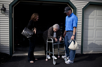 Kelley and her brother, David, wait for their grandmother to catch her breath as she moves from the living room to the car. AnnaBelle's mobility is significantly hampered by rheumatoid arthritis.