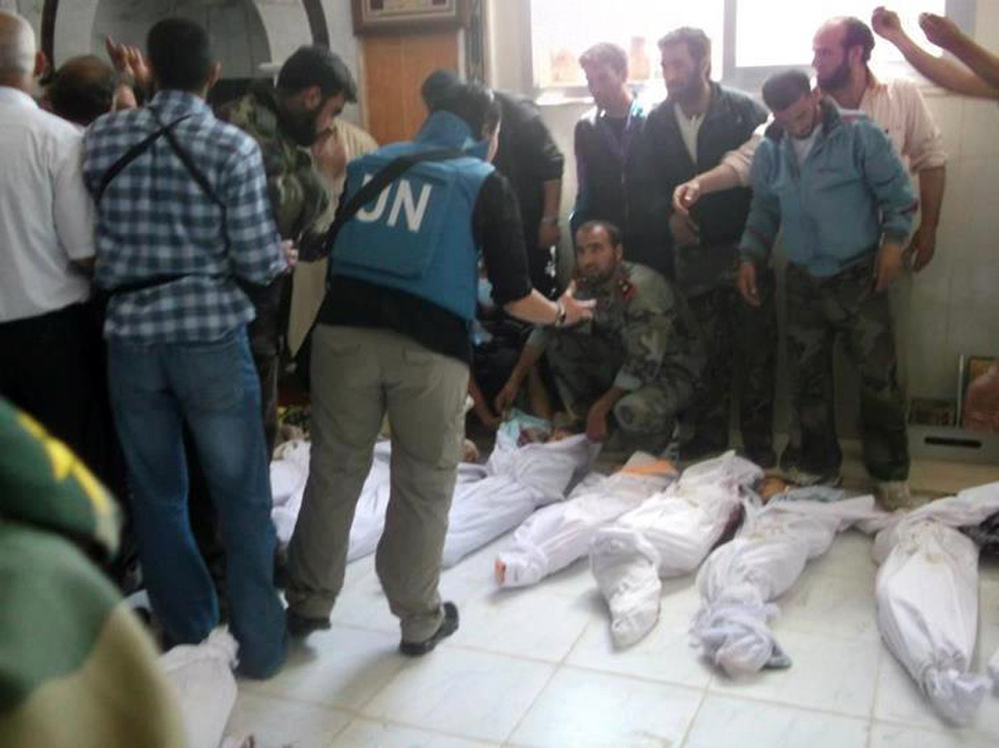 A handout picture released by the Syrian opposition's Shaam News Network shows UN observers at a hospital morgue in the central Syrian town of Houla on Saturday.