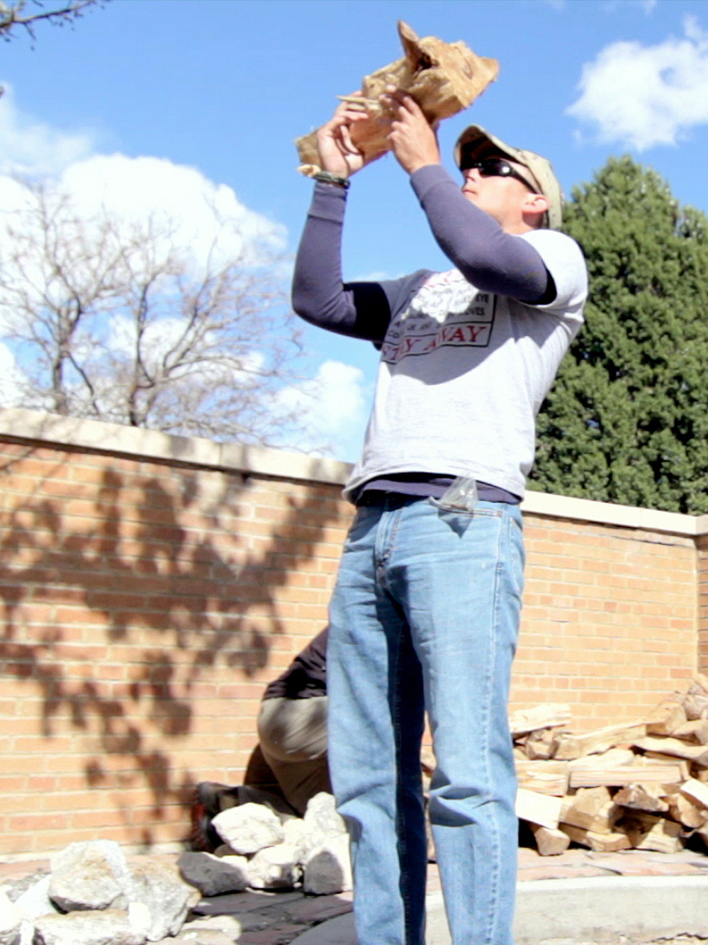 Veteran Steve Rich prays before placing a log in the fire pit.
