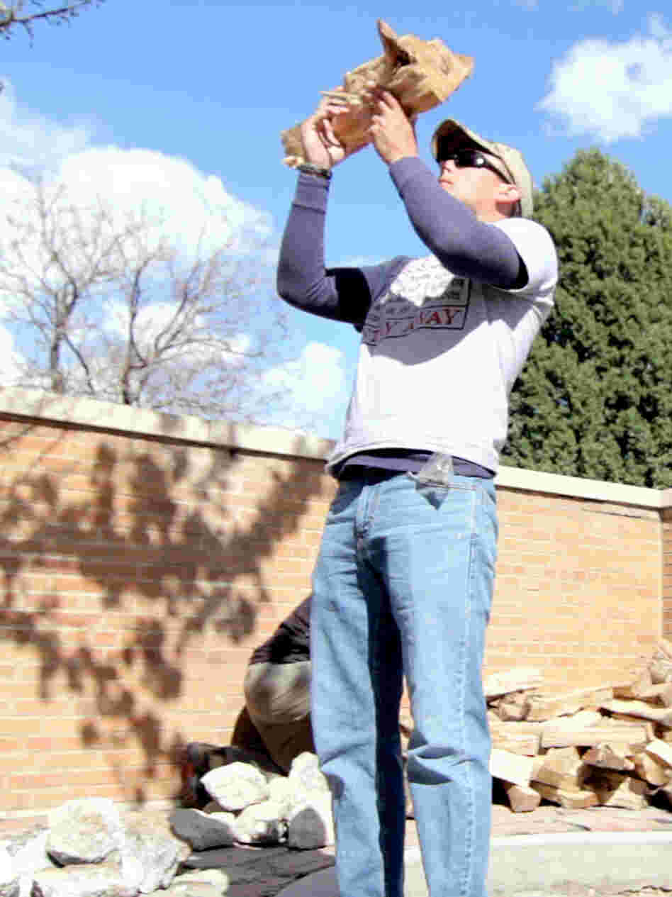 Veteran Steve Rich prays before placing a log in the fire pit.