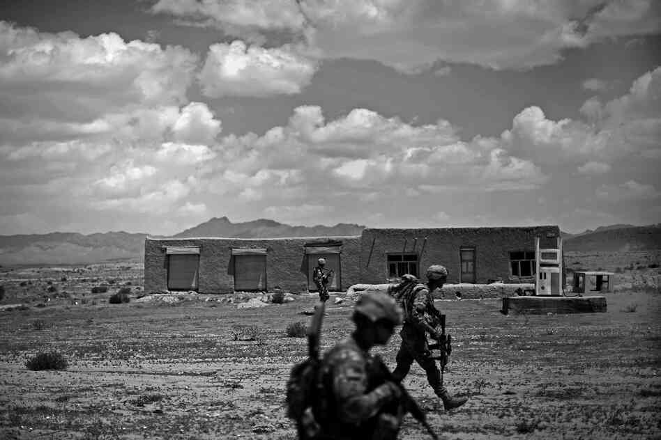 Soldiers walk past an abandoned gas station after a gun battle with insurgents near the village of Pana, Ghazni province.