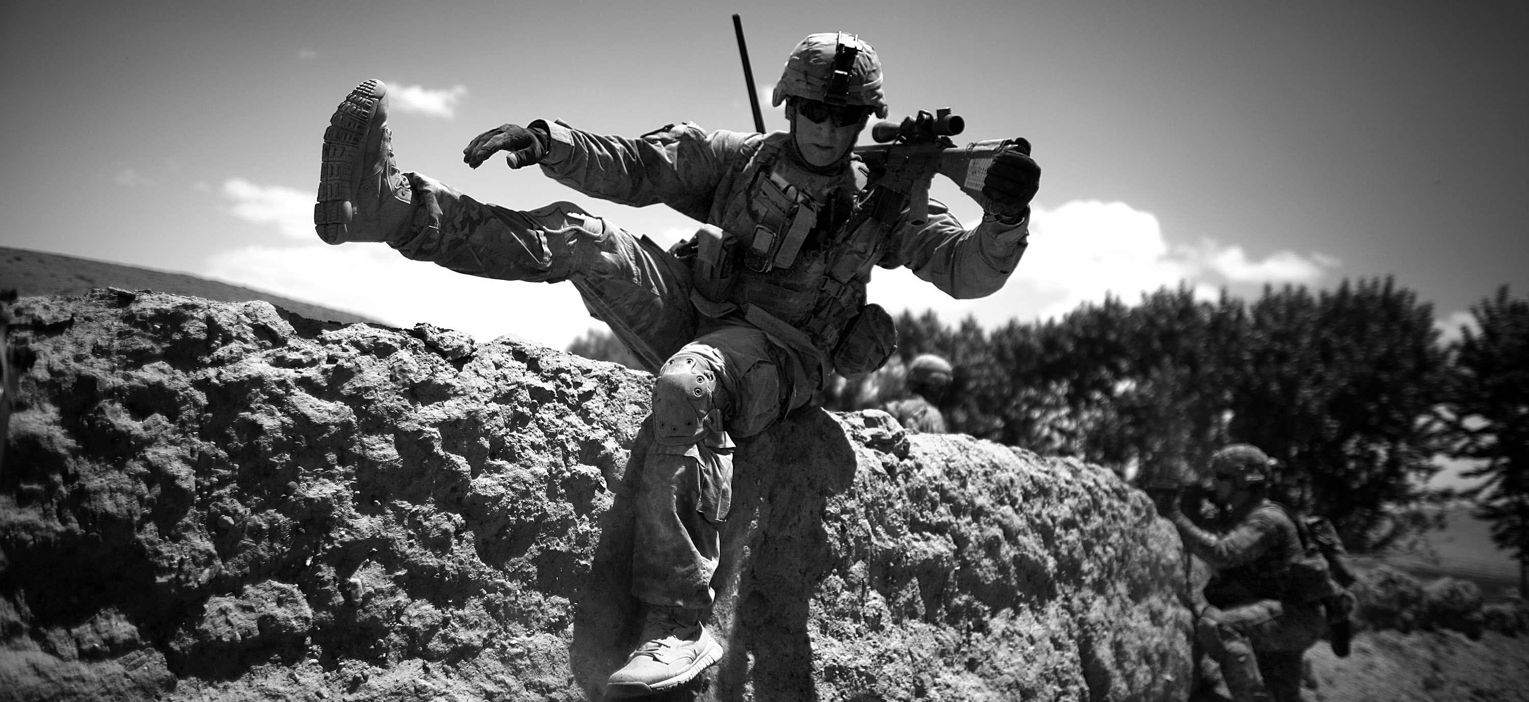 Staff Sgt. Laverne Schwartz takes up position as insurgent rounds hit the other side of a mud wall used for cover.
