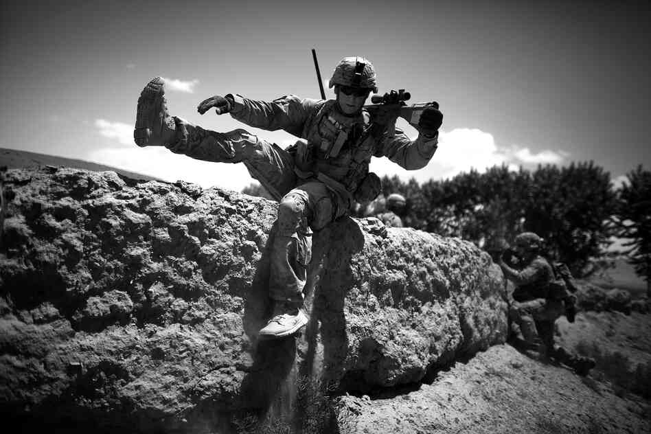 Staff Sgt. Laverne Schwartz takes up position as insurgent rounds hit the other side of a mud wall used for cover.