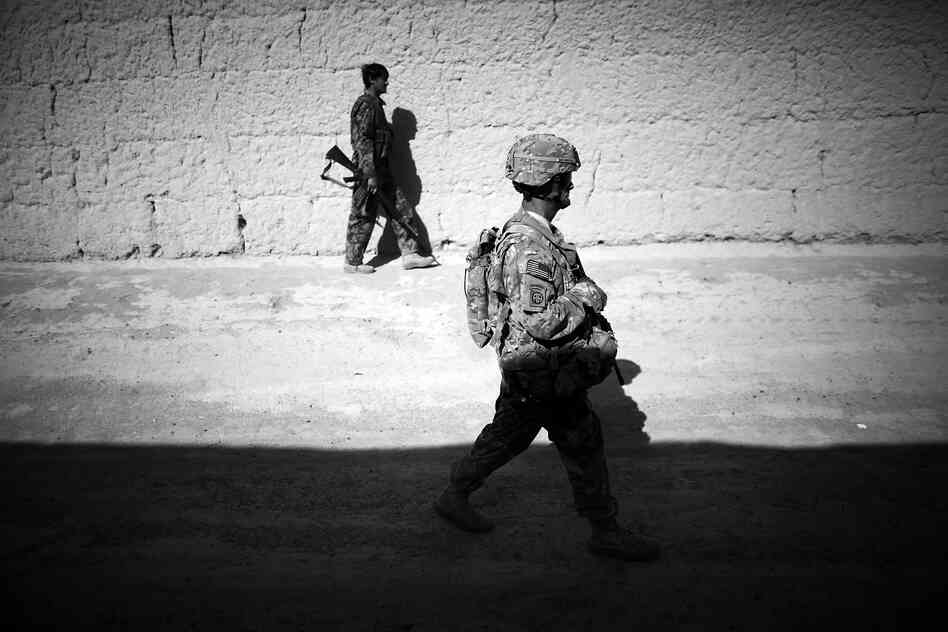 Sgt. 1st Class John Foster, with the Security Force Assistance Team attached to the 82nd Airborne, walks with an Afghan National Army soldier between mud-walled compounds in Babaker.