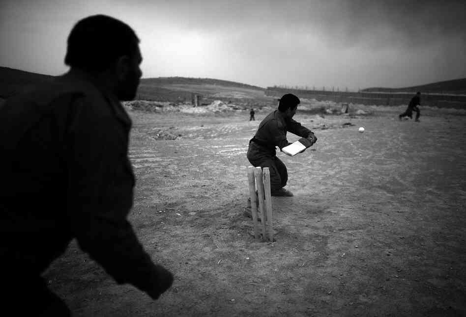 Officers with the Afghan National Police play cricket on the hillside next to Forward Operating Base Giro. The Afghan National Army, National Directorate of Security and Afghan National Police all share space with the soldiers from the 82nd Airborne. The transition from NATO forces to Afghan-led bases and daily operations is one of the key U.S. goals in Afghanistan this summer.