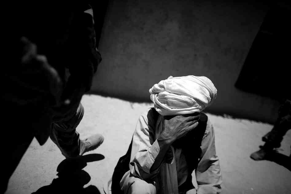 Afghan soldiers and officers with the National Directorate of Security question the father of a suspected Taliban facilitator who is wanted for his involvement in building and placing homemade bombs in Giro district.