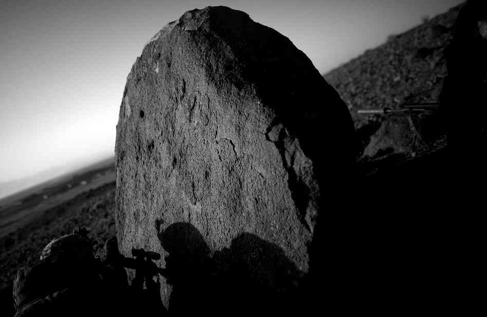 A sniper with the 82nd Airborne looks for enemy activity from behind the cover of a boulder near the village of Pana.