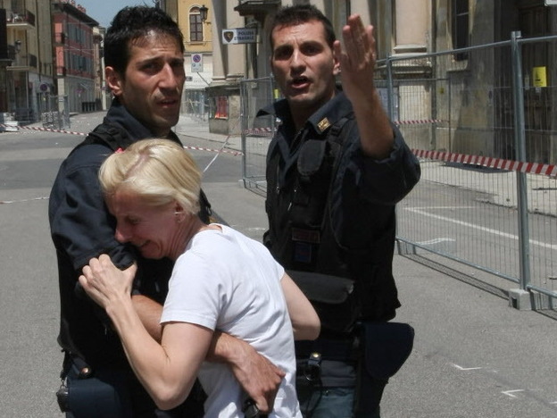 Two police officers in Mirandola try to comfort a woman after today's earthquake in Northern Italy.