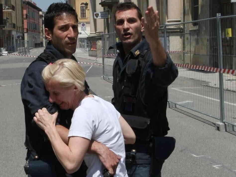 Two police officers in Mirandola try to comfort a woman after today's earthquake in Northern Italy.