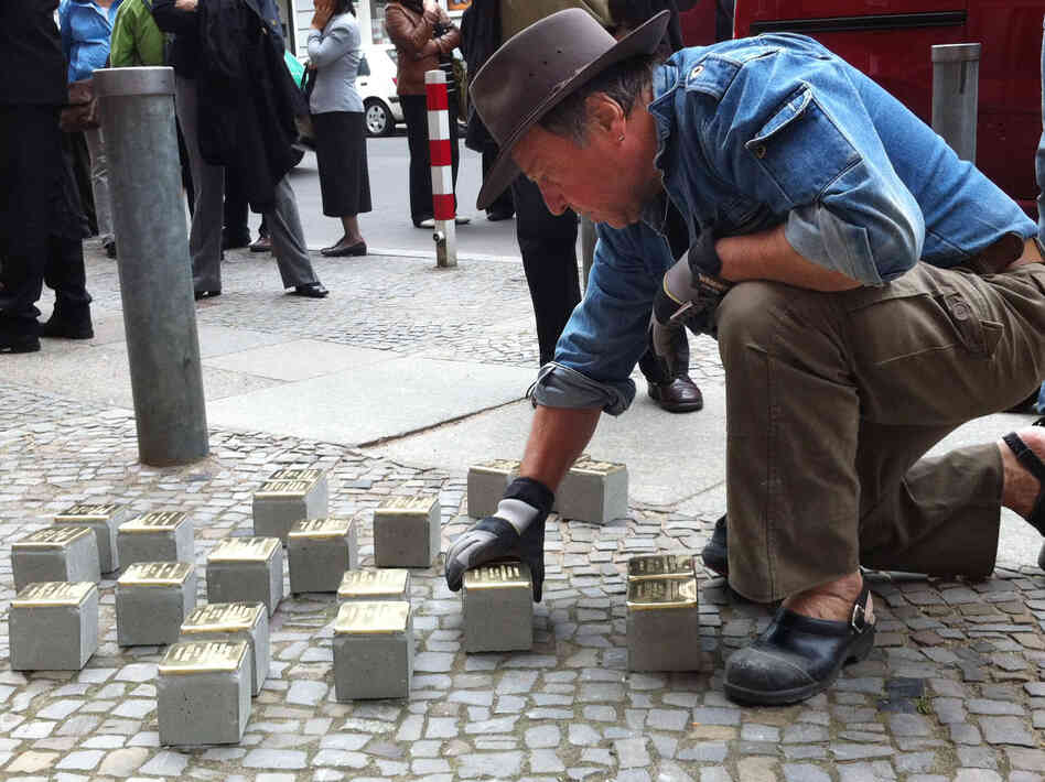 Guenther Demnig is the artist and sculptor behind the stumbling stones. Here, he installs new bricks in Berlin. He says formal memorials are too abstract. Not so with the stumbling stones. "Suddenly they are there, right outside your front door, at your feet, in front of you," he says.
