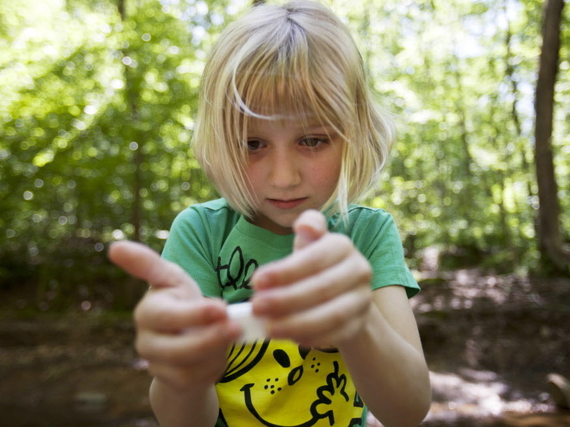 Lori Anne Madison, 6, studies a snail while also giving an interview to The Associated Press about being the youngest-ever competitor in the National Spelling Bee.